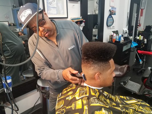 Barber cutting a sharp fade for a client, Seattle barbershop